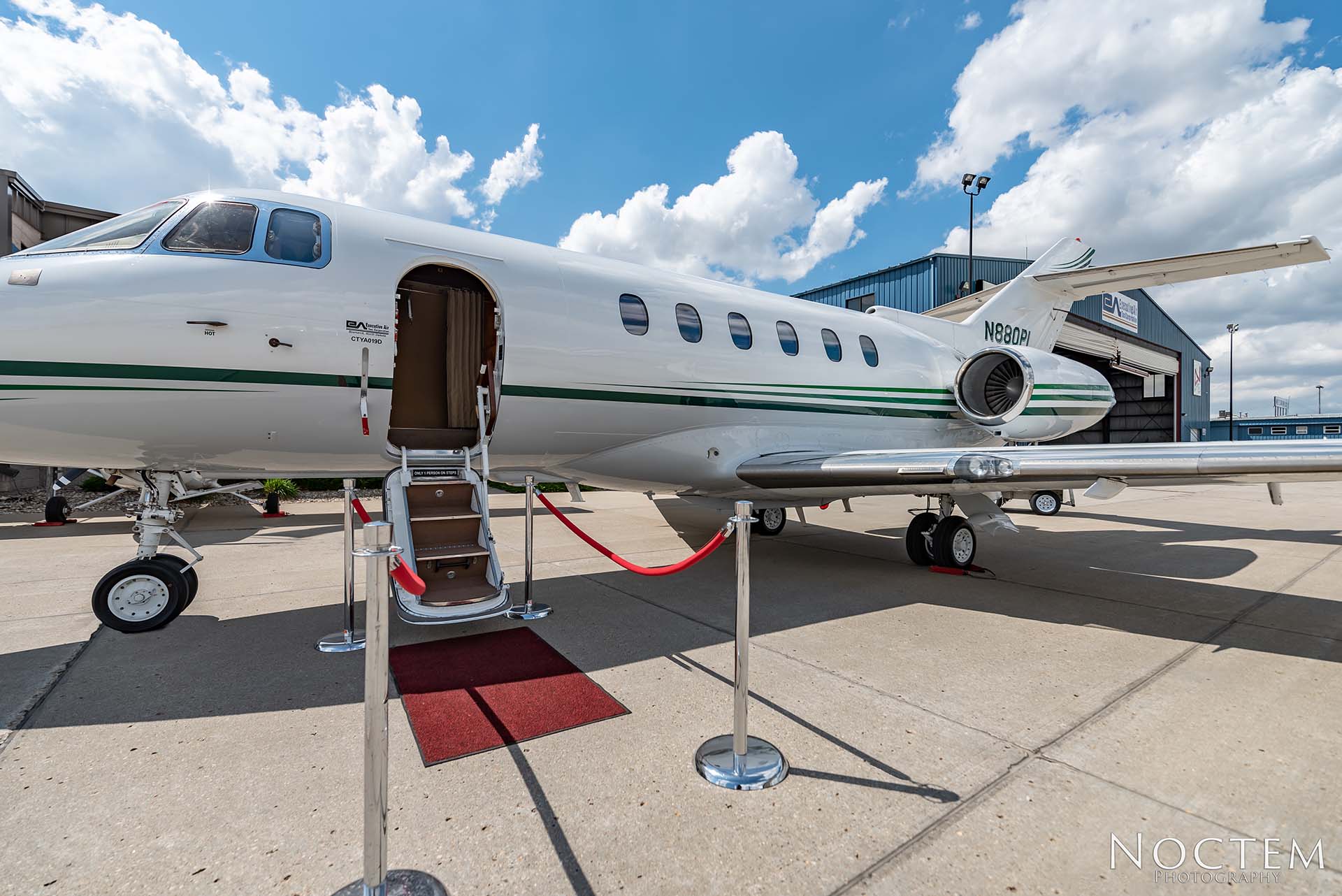 closer Hawker 800XP outside view with open door and red carpet leading to entrance