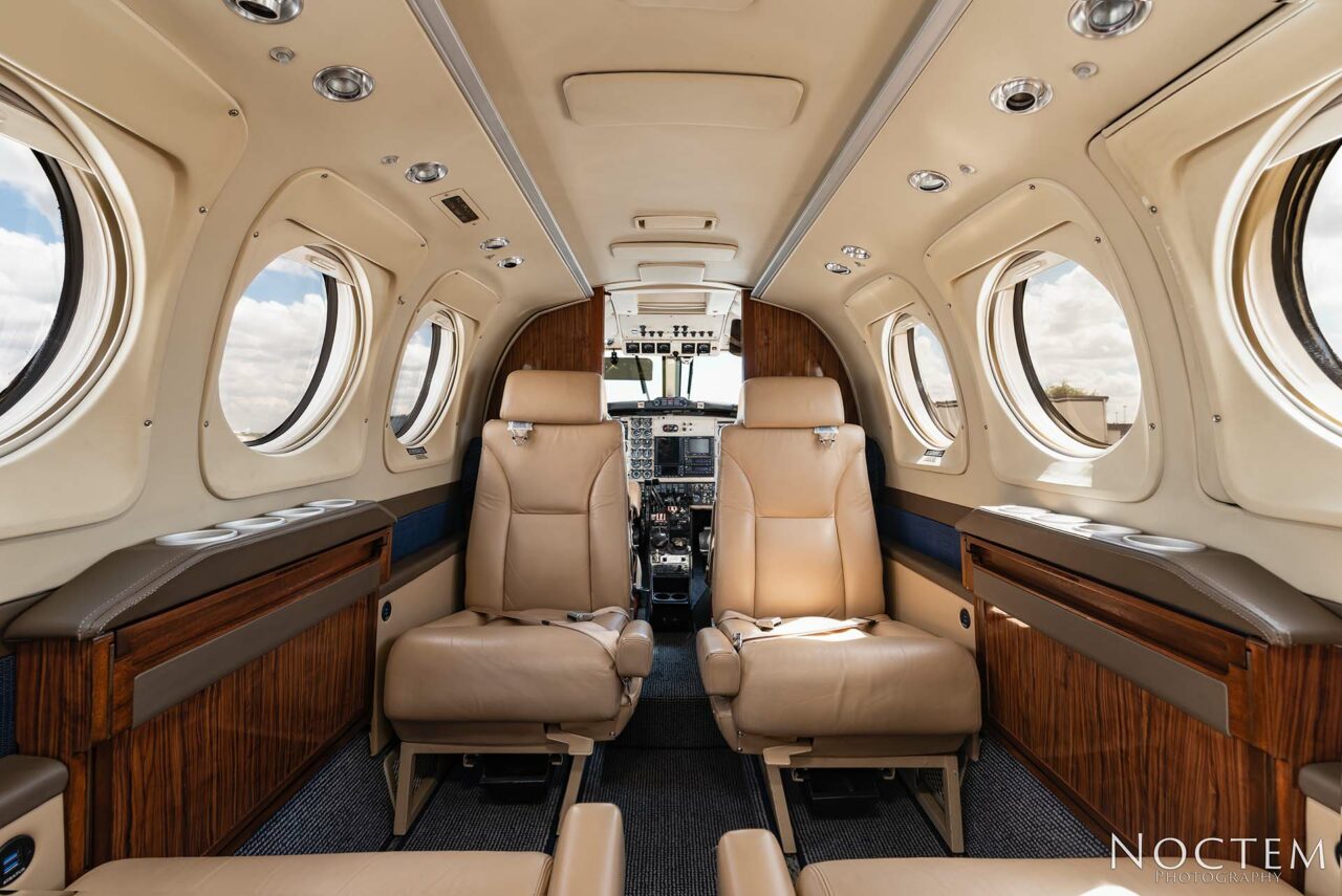 Seating inside King Air E90 with doorway leading to cockpit
